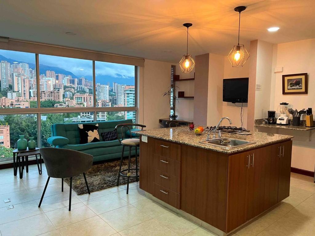 a kitchen and living room with a view of a city at Exclusive apt in Poblado, Central location in Medellín