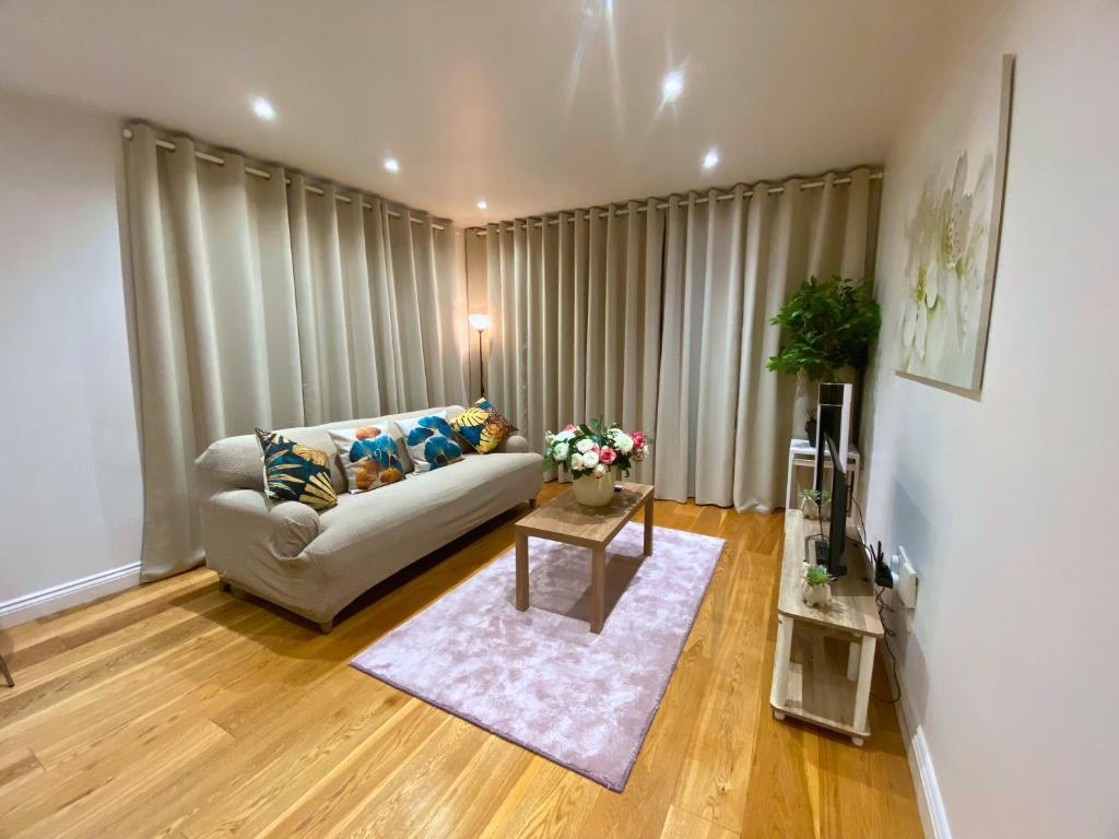 a living room with a couch and a table at Executive North London Southgate Serviced Apartment - Contractors Ready in East Barnet