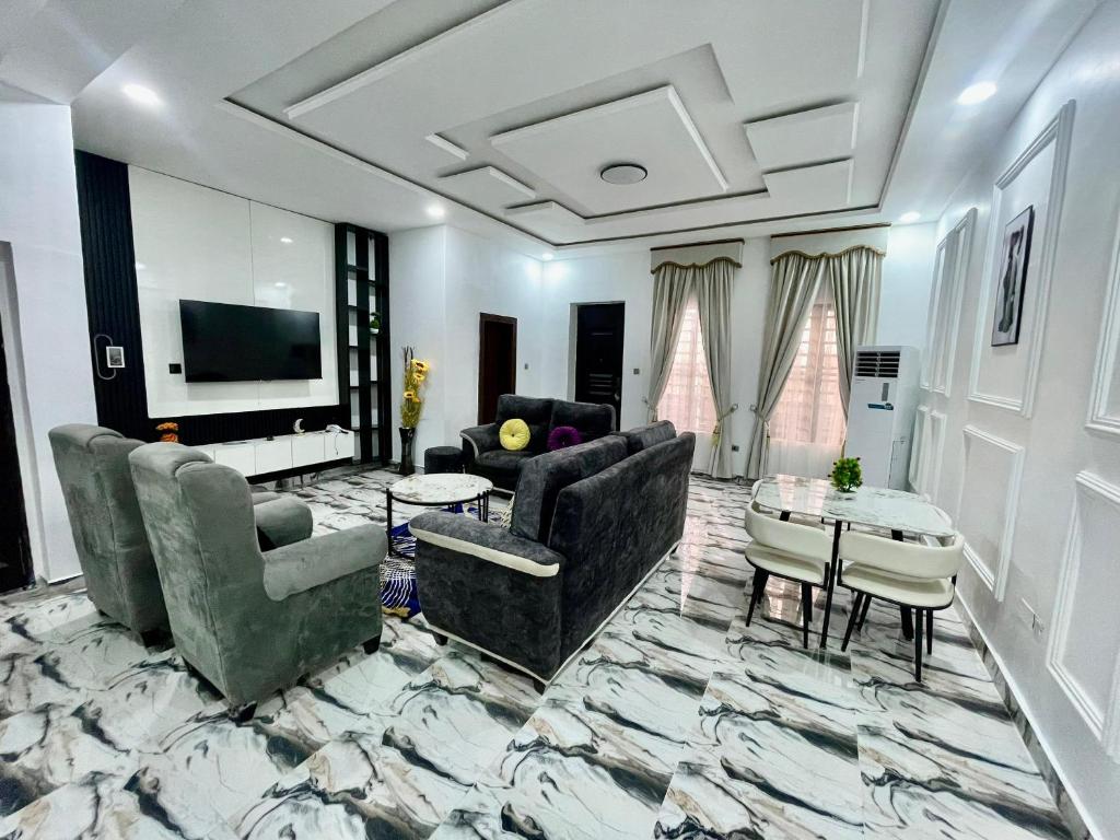 ポートハーコートにあるGlenns Apartmentのソファとテレビ付きの広いリビングルーム