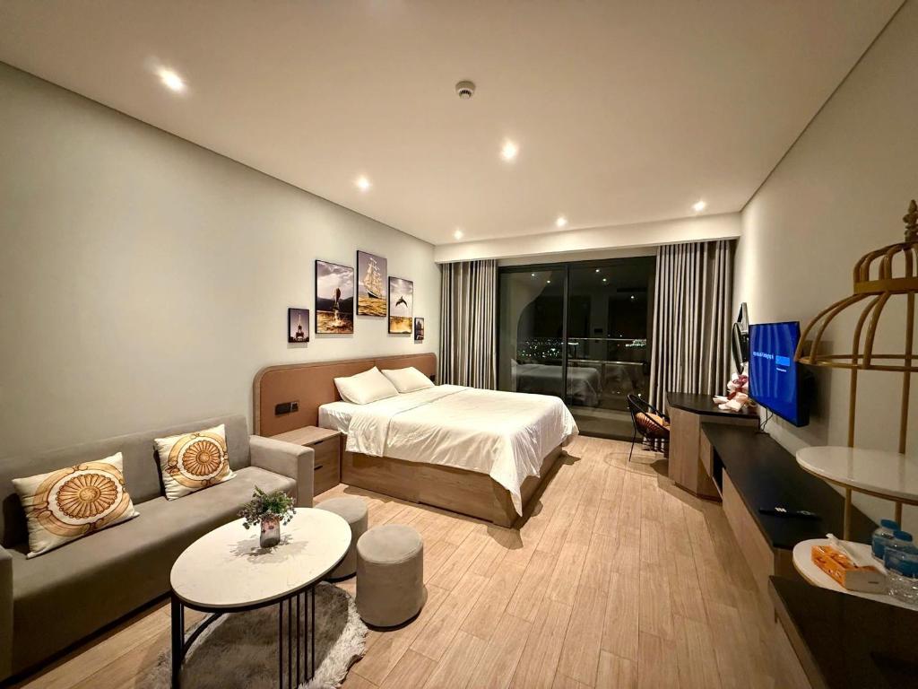 ハロンにあるchuỗi căn hộ Citadines hướng biểnのベッドとソファのあるホテルの部屋
