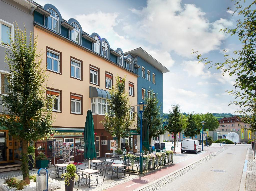 - un bâtiment dans une rue avec des tables et des chaises dans l'établissement Wohlfühlappartements Bayer, à Bad Schallerbach