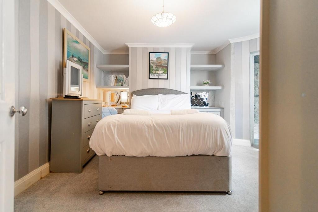 ラムズゲートにあるCharming 6 Bedroom Townhouse by the Seaside - Balcony, Self-Check-In, Fast WiFi and Smart TVs by Yoko Propertyのベッドとテレビのある寝室