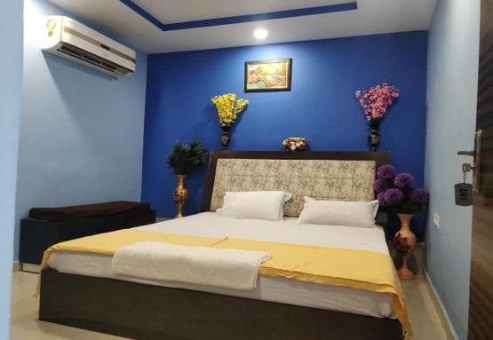 a bedroom with a large bed with a blue wall at RD Residency Hotel at IIT Gate Kanpur in Kānpur