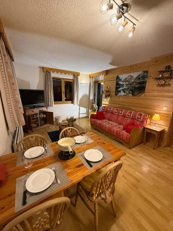 a living room with a table and chairs and a couch at Appartement Samoens Cosy in Samoëns