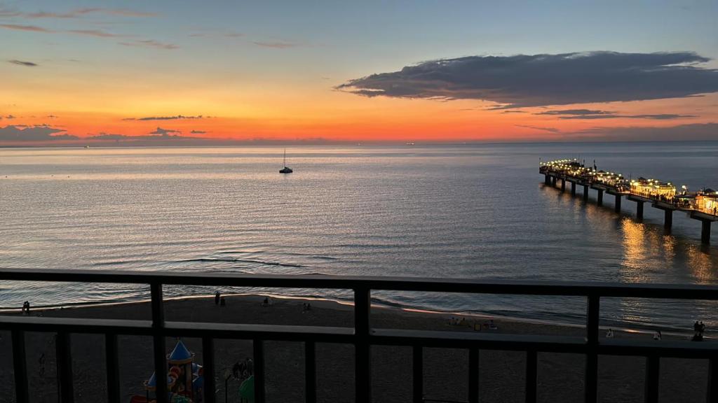 un muelle en la playa con un barco en el agua en Baltic Infinity Sea&Beach Międzyzdroje, en Międzyzdroje