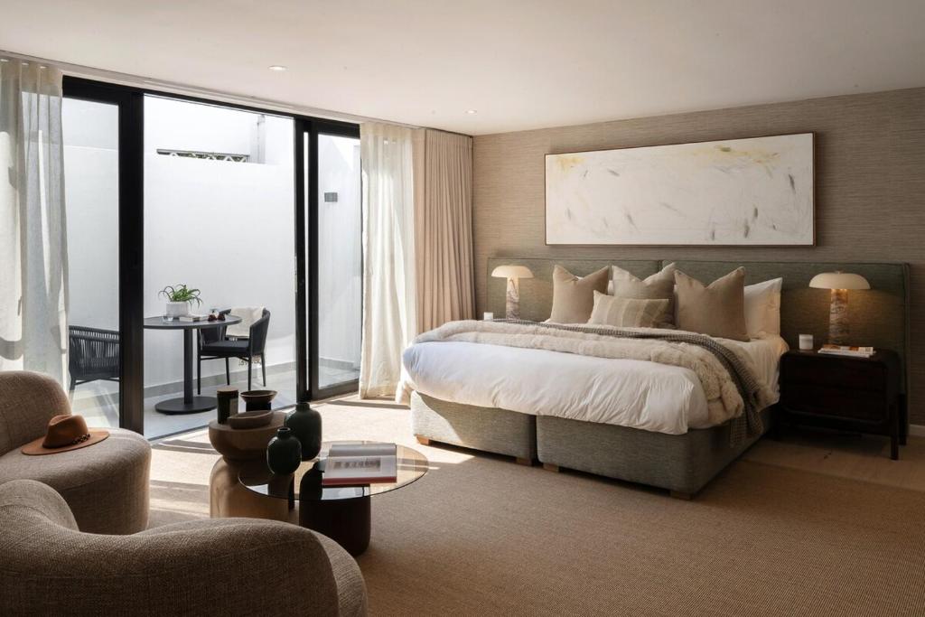 een slaapkamer met een groot bed en een woonkamer bij Satori Lodge by Bliss Collection in Kaapstad