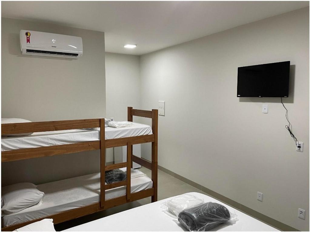 une chambre avec deux lits superposés et une télévision à écran plat dans l'établissement Camping Rio Formoso, à Bonito