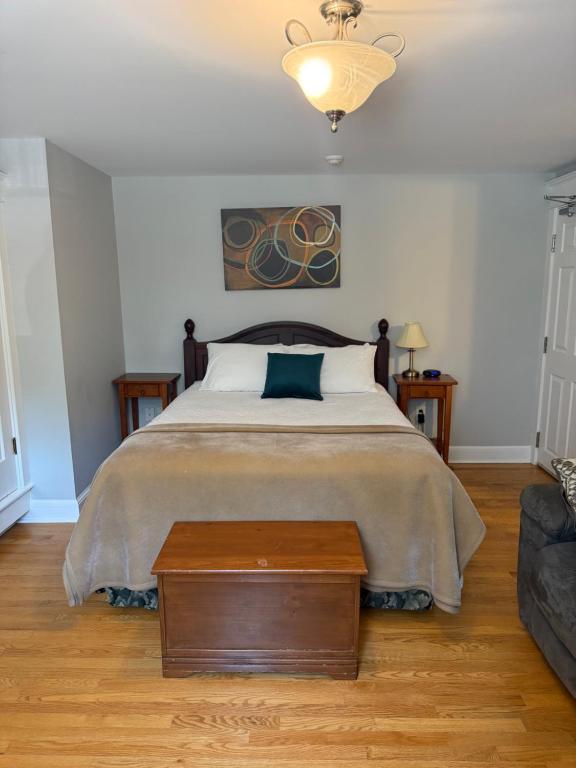 a bedroom with a bed with a table and a couch at Midstream Manor Unit 3, Studio in St. John's