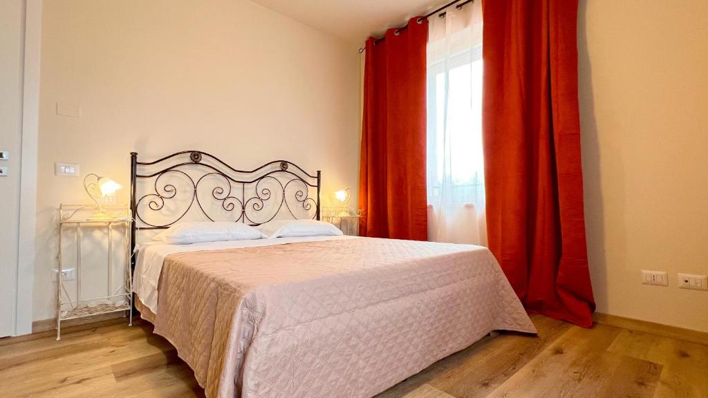 a bedroom with a bed and a window with red curtains at Casa Salcheto in Montepulciano