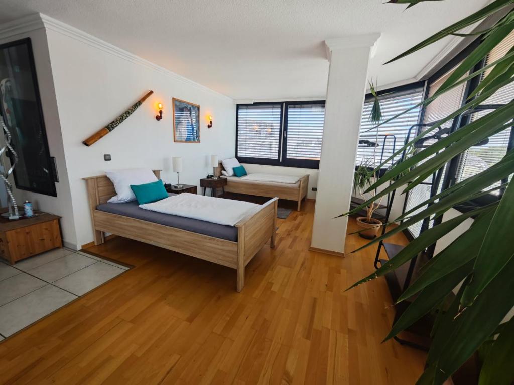 a bedroom with a bed and a living room at Im Herzen von Wiesdorf- Blick auf das BAYER-KREUZ -Appartement mit 2 Schlafzimmern & 3 Betten-für 4 Personen -Zentral gelegen - Friedrich Ebert Platz 5a , 4te Etage - Dachterrasse und Sauna - Kaution Pflicht - in Leverkusen