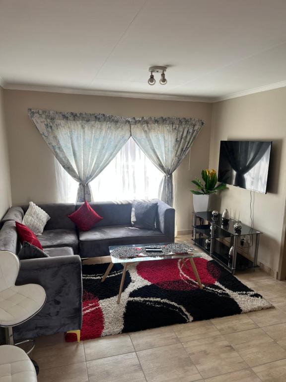 a living room with a couch and a table at Modern Style Apartments, An Escape From The City in Pretoria