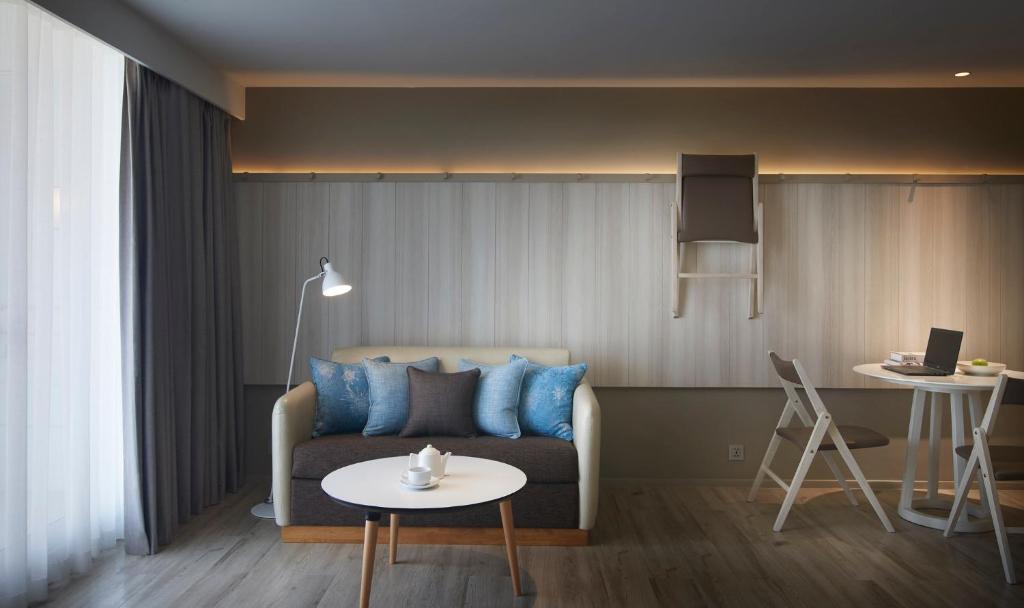 A living room with a sofa, small dining desk and laptop-ready surface.