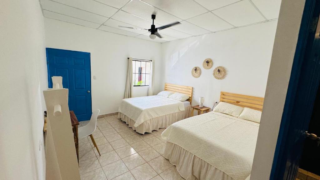 ein Schlafzimmer mit zwei Betten und einem Deckenventilator in der Unterkunft Habitación junto a la Catedral de Santa Ana - La Casa de Moris in Santa Ana