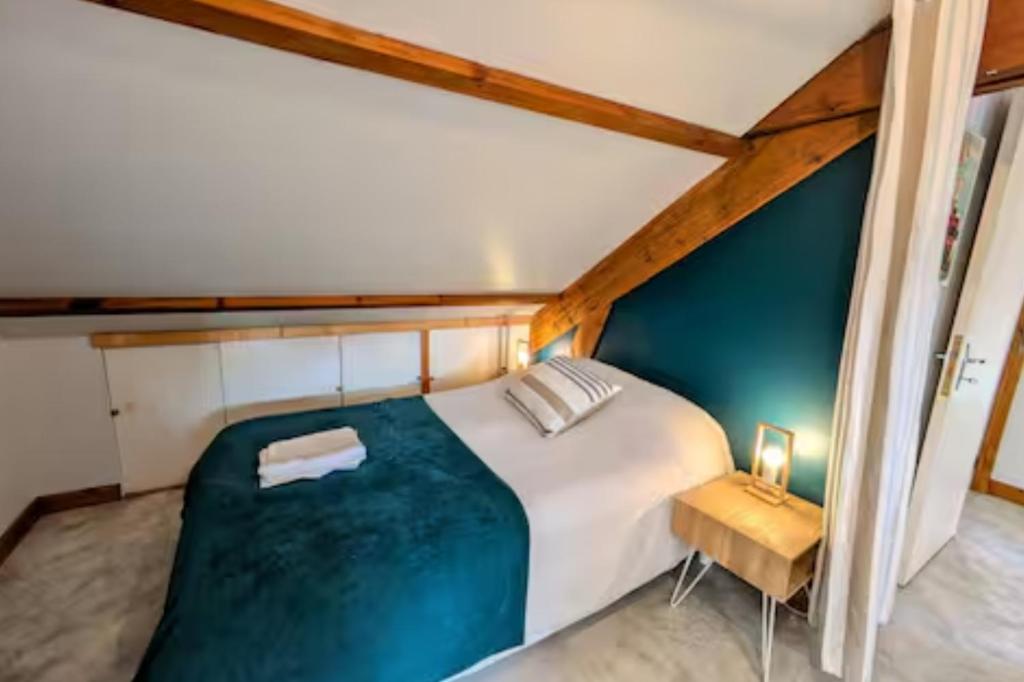 a bedroom with a large white bed and a table at Maison cozy plage & jardin in Saint-Brevin-les-Pins