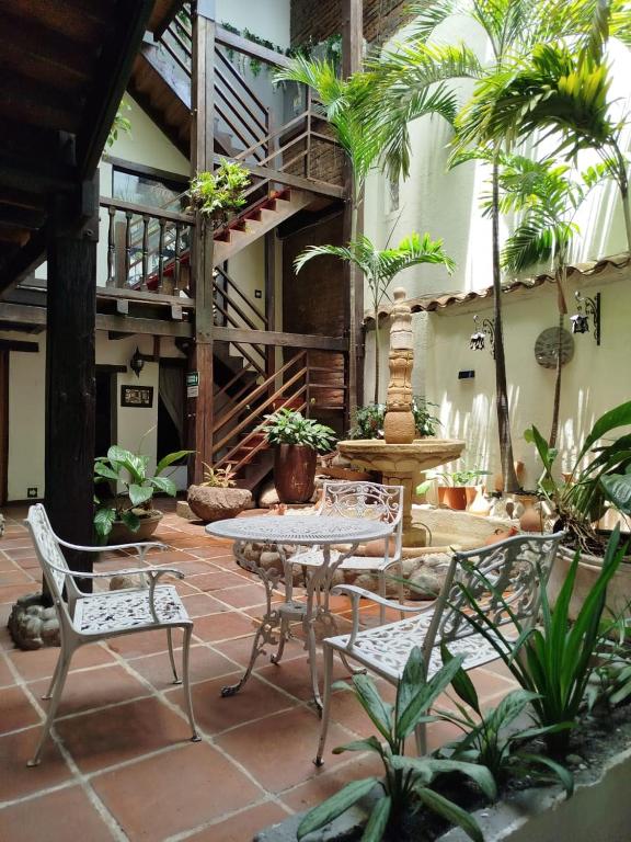 a patio with a table and chairs and a staircase at Hotel Terraza San Antonio in Cali