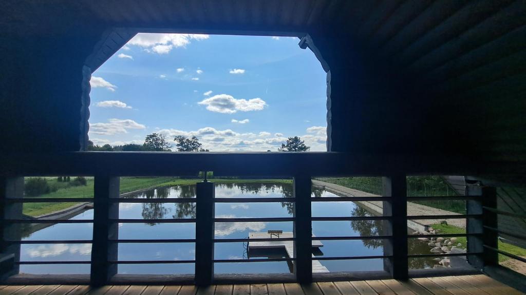 a window in a building with a view of a lake at Ūdros slėnis in Bildžiai
