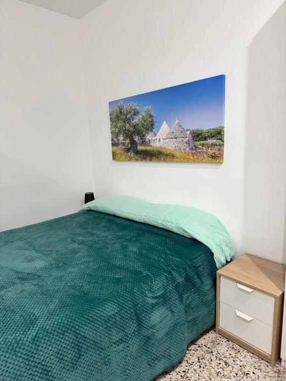 a bedroom with a bed and a picture on the wall at Casetta Silvia in Brindisi