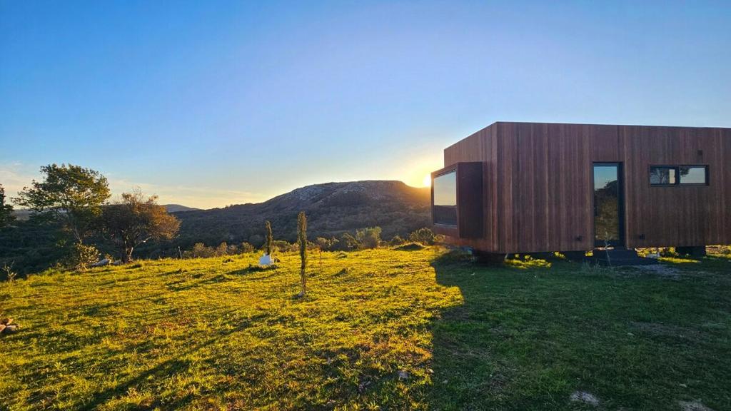 una casa su una collina con il tramonto sullo sfondo di NEW! Casa de campo con diseño - Casa Armonia Uruguay a Aiguá