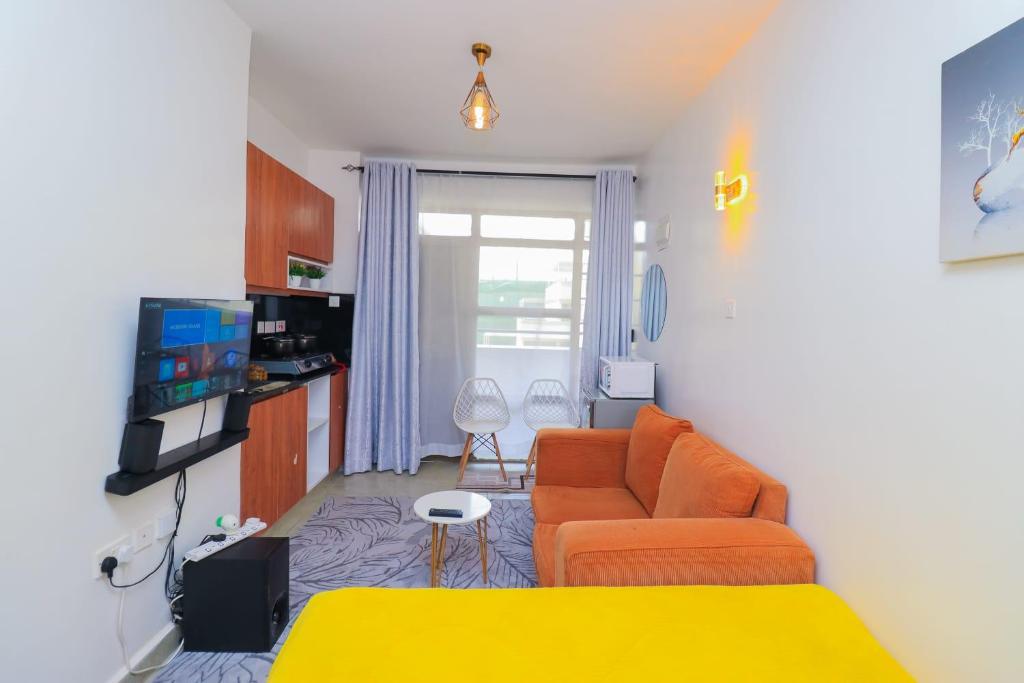 a living room with a couch and a tv at Comfort Homes Roysambu in Nairobi
