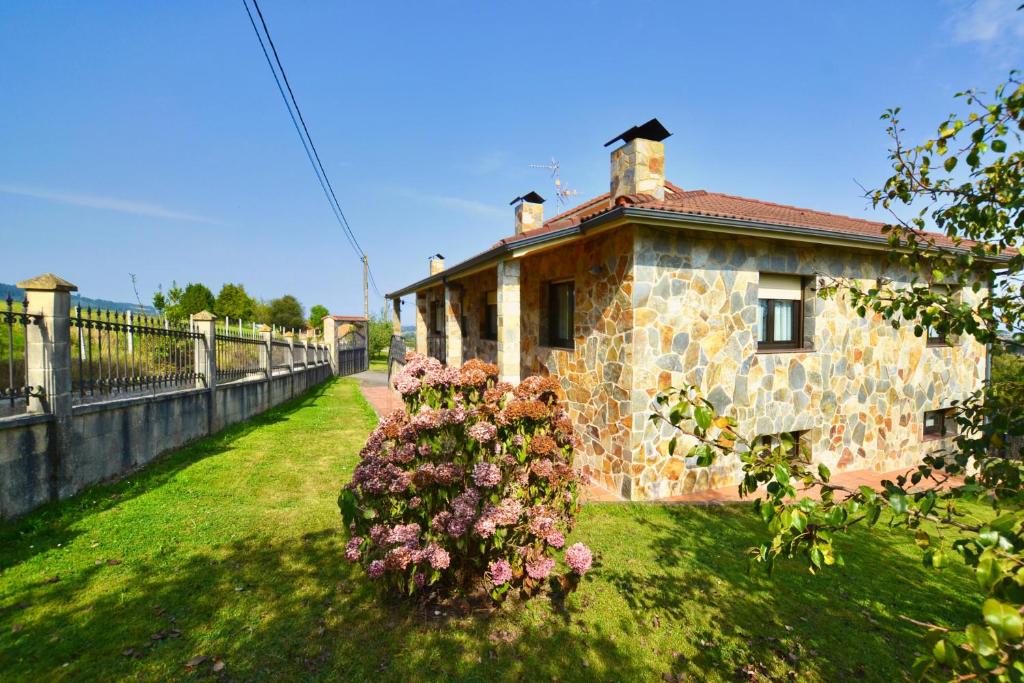 a stone house with flowers in front of it at 210A Casa Linares Amplia casa en Villaviciosa in Cadamancio
