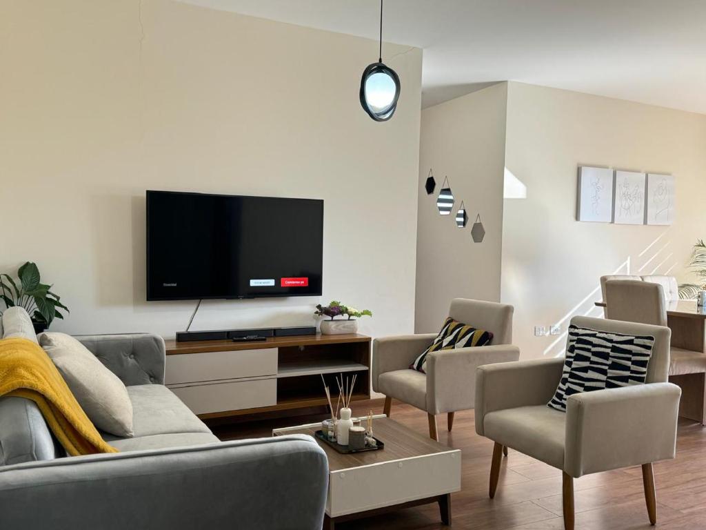salon z kanapą i telewizorem w obiekcie Familiar con terraza privada zona norte w mieście Cochabamba