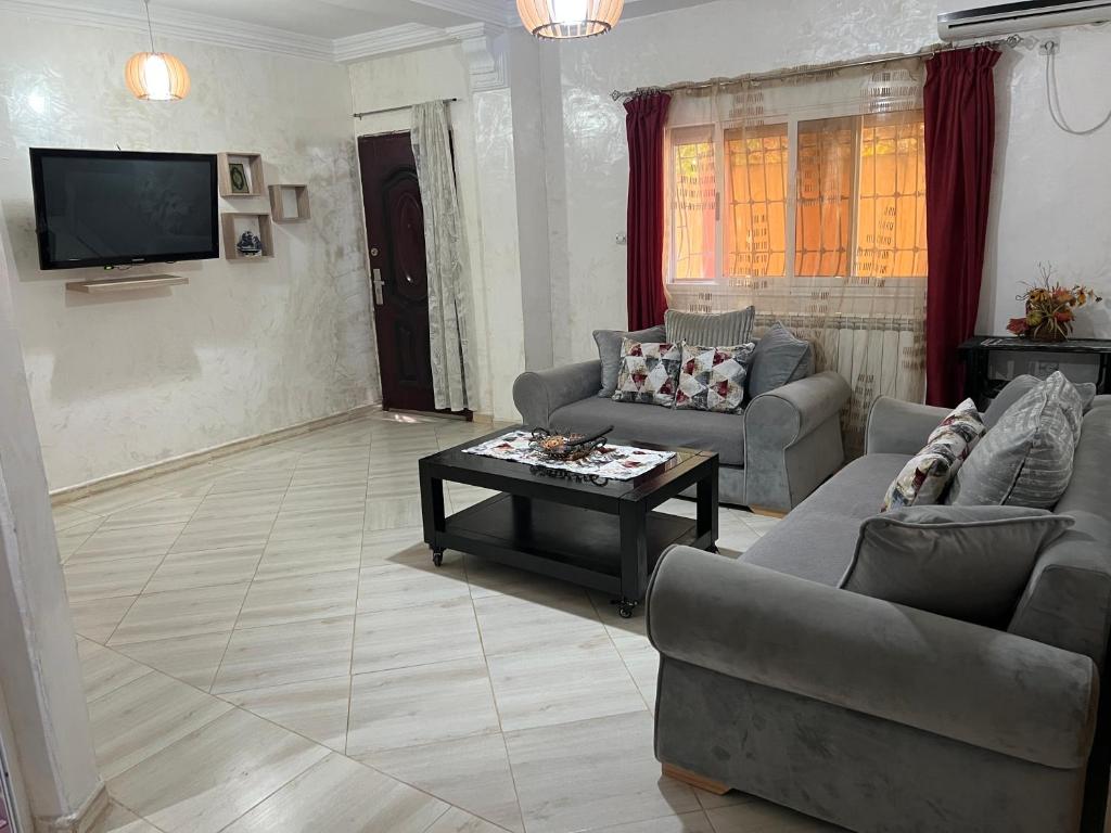 a living room with two couches and a coffee table at Étage de villa Elkala in El Kala