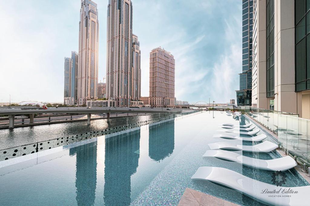 a pool of water in a city with tall buildings at Luxury Apartments - Urban Oasis by Missoni - Business Bay - Canal View - 10 Minutes from Dubai Mall Burj Khalifa in Dubai