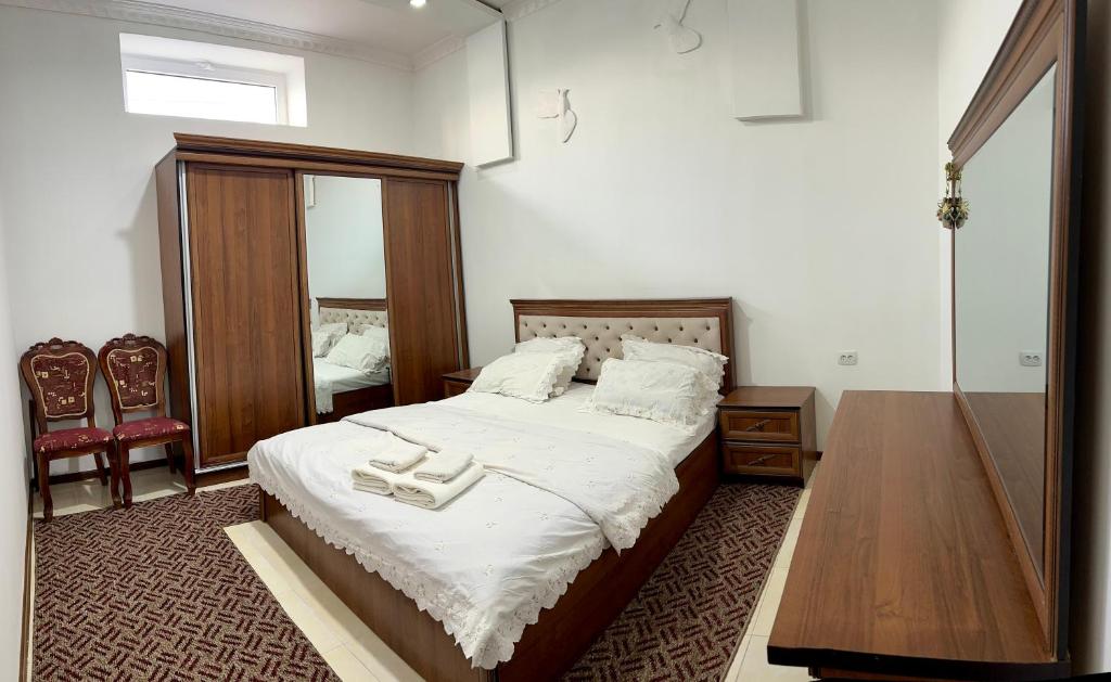 a bedroom with a bed with two white shoes on it at The Homely Stay in Bukhara