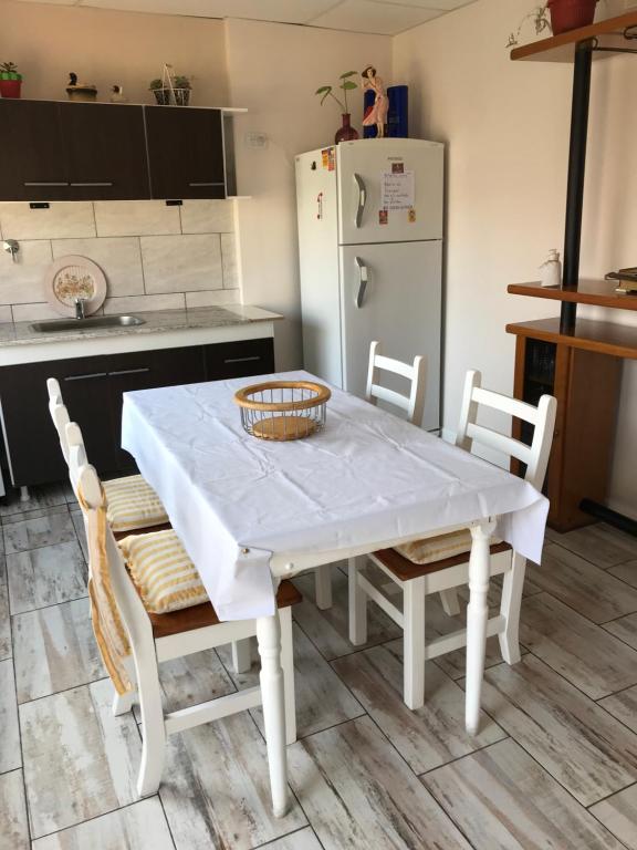 a kitchen with a white table and chairs and a refrigerator at Las Heras in Olavarría