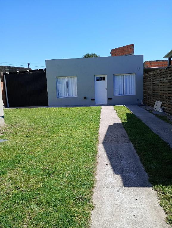 a house with a grassy yard in front of it at Las ruinas 1 in Carhué
