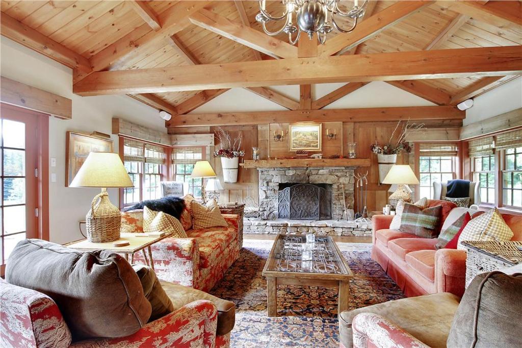 a living room with couches and a fireplace at Soupcon: 4 br, fireplaces, game room, sauna, hot tub, views in Stowe