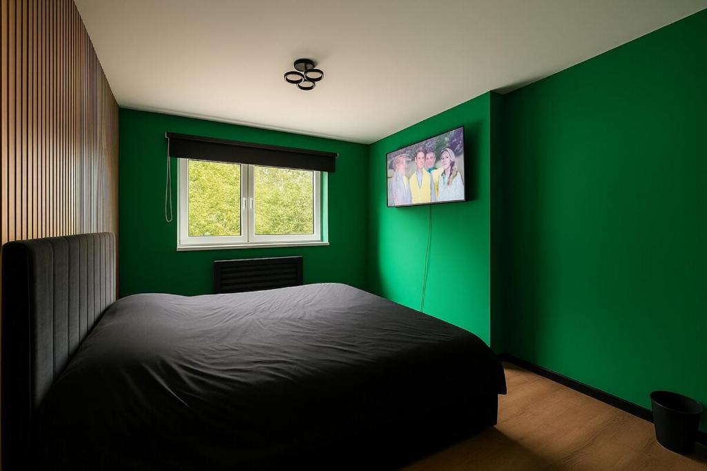 a green bedroom with a bed and a window at Luxury sanctuary in Moortown