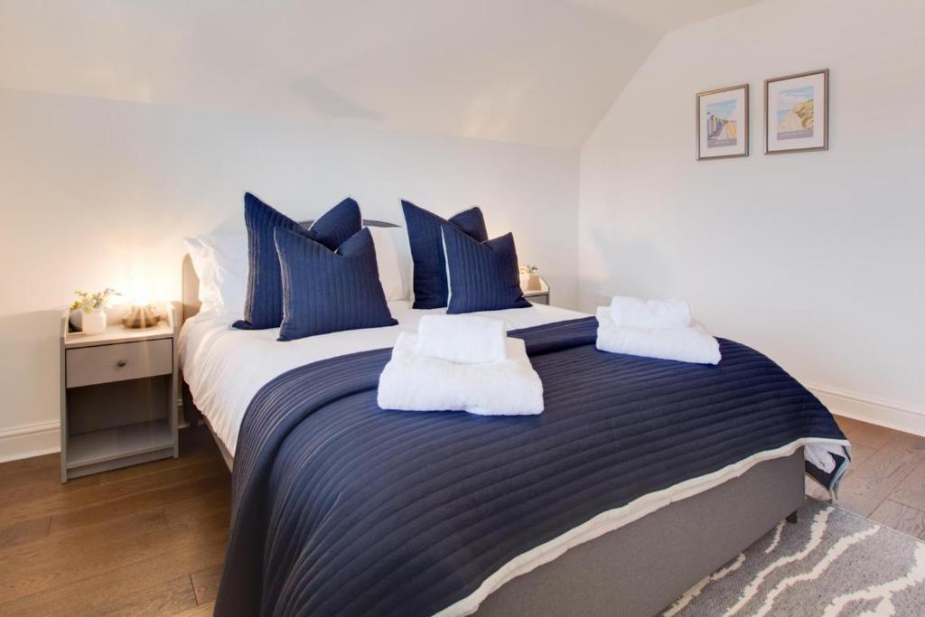 BodhamにあるDenbury Houseのベッドルーム1室(大型ベッド1台、青と白の枕付)