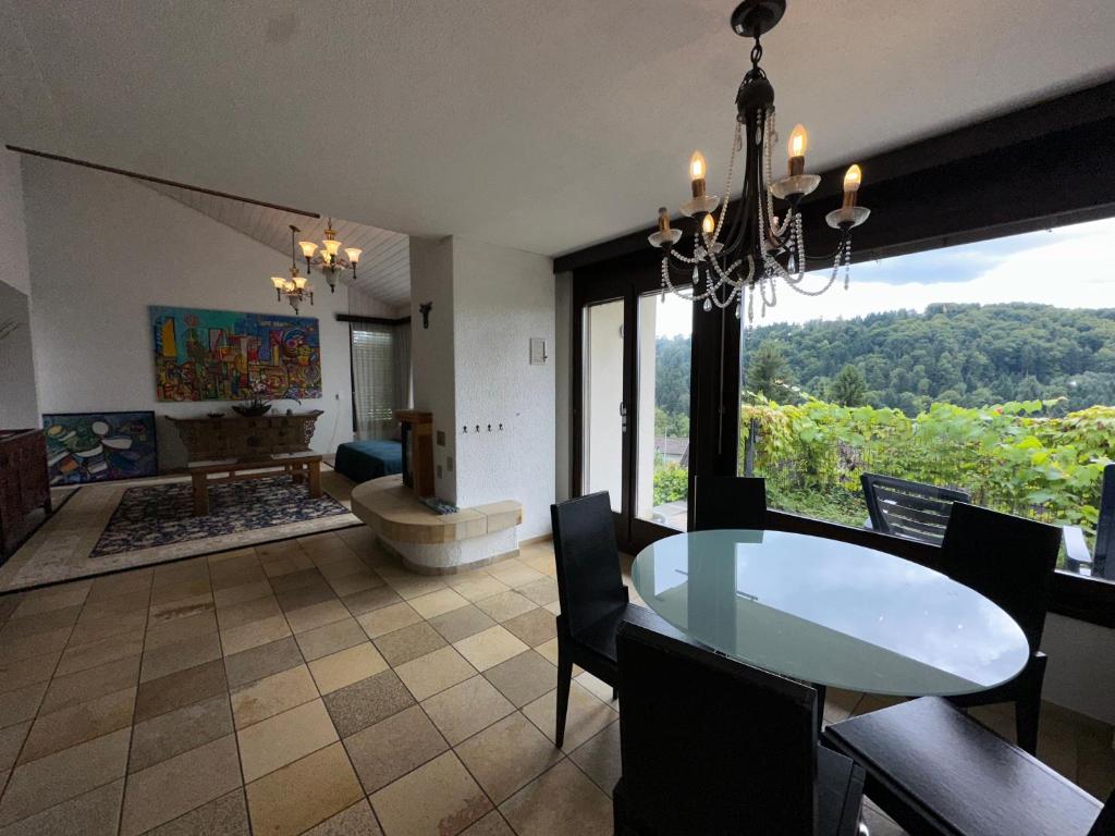 una sala da pranzo e un soggiorno con lampadario pendente. di Beautiful apartment near Luzern, view to Rigi,Pilatus Mountain a Lucerna