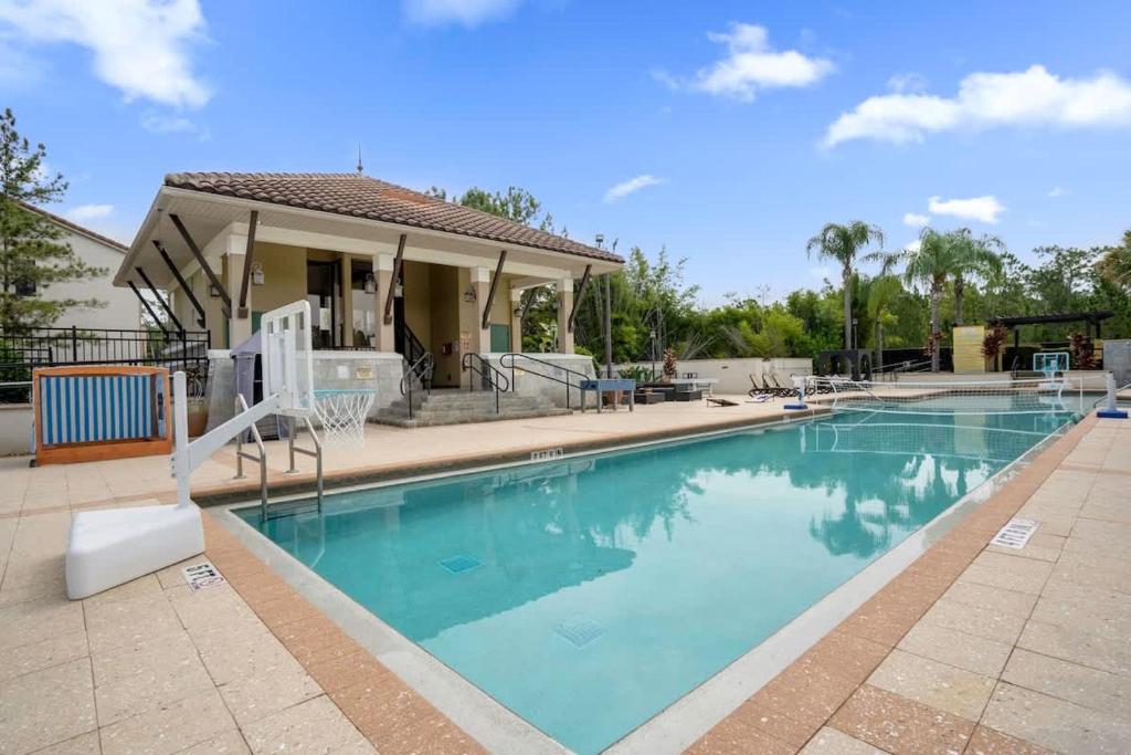 Hotel Cozy & Elegant 4BR Enchanted Townhouse - 1 Mile to Disney with Resort Pool, Gym, & Jacuzzi, a swimming pool in front of a house at Cozy & Elegant 4BR Enchanted Townhouse - 1 Mile to Disney with Resort Pool, Gym, & Jacuzzi in Orlando