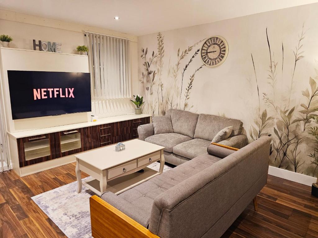 a living room with a couch and a tv at Spacious 2-bedroom Flat, Edgware London in Edgware