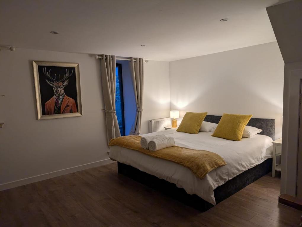 a bedroom with a bed and a picture of a deer on the wall at Tomnauld Farm Wellness Cottage in Pitlochry