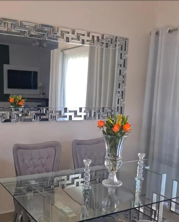 a dining room with a glass table and a mirror at Lerewa in Gaborone