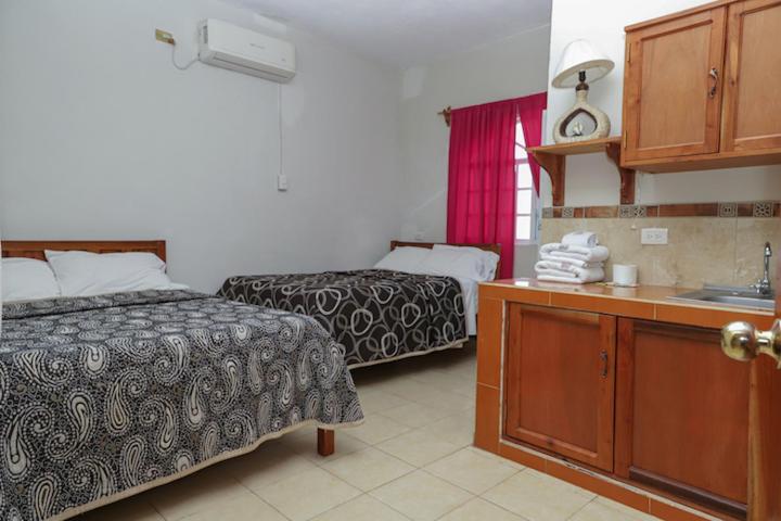 a hotel room with two beds and a sink at Hotel Bugambilias ciudad valles slp in Ciudad Valles