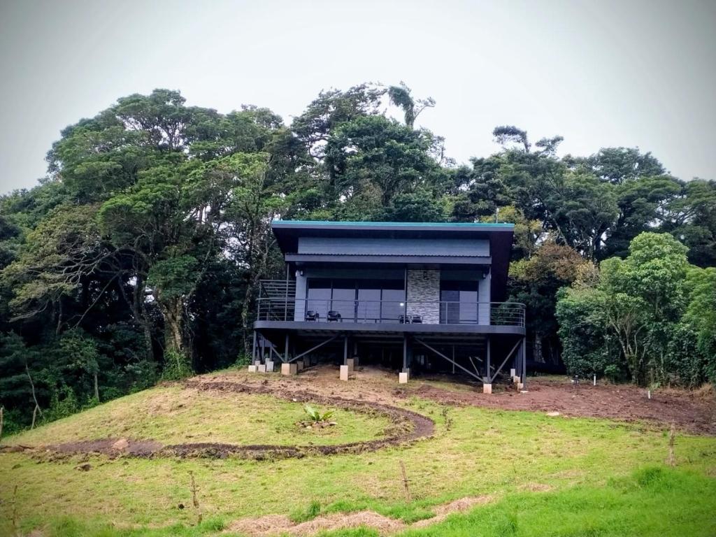 una casa en la cima de una colina con árboles en Villa Centinela, en Monteverde