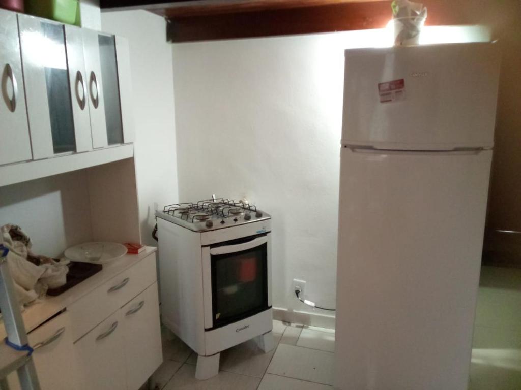 a kitchen with a white stove and a refrigerator at Flet Beira Mar in Rio de Janeiro