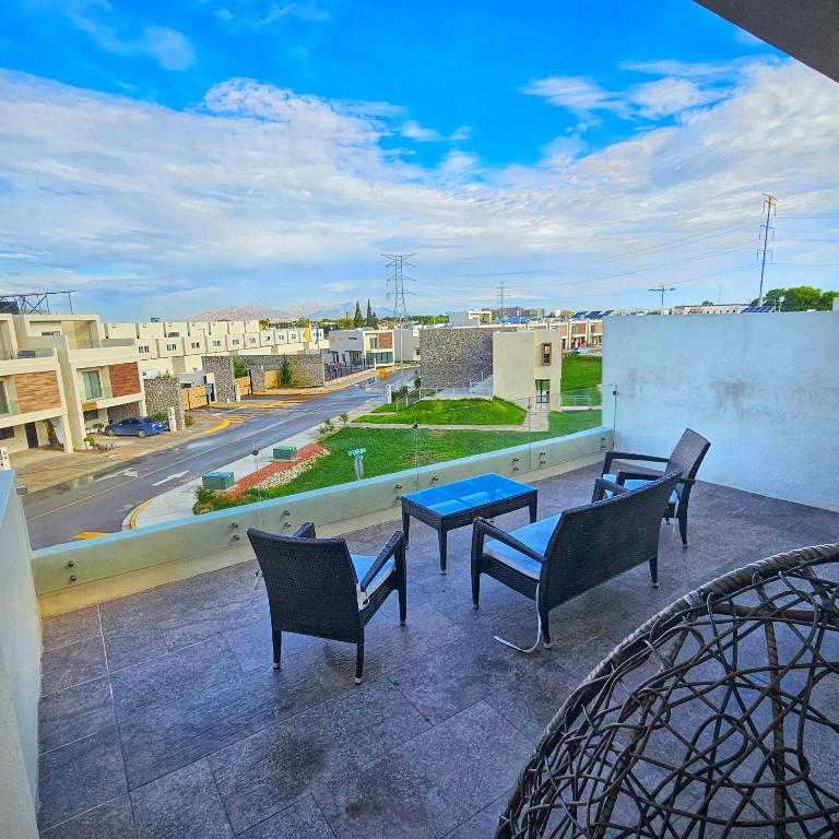 a balcony with chairs and a table and a view of a city at Vane's House Consulado in Ciudad Juárez
