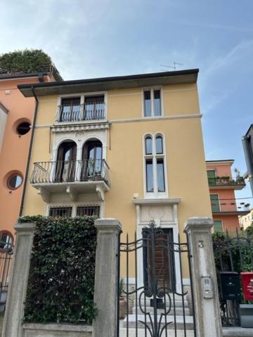 Casa amarilla con balcón y valla en Marcella Grand Apartment, en Verona