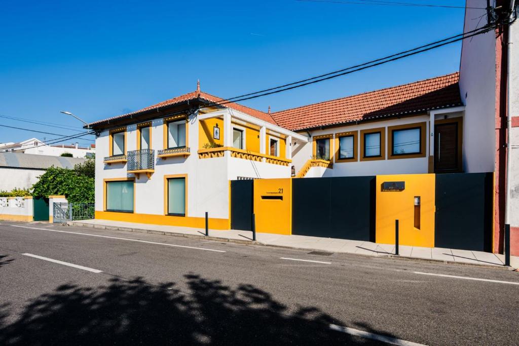 a yellow and white building on the side of a street at Trilogia in Lousã
