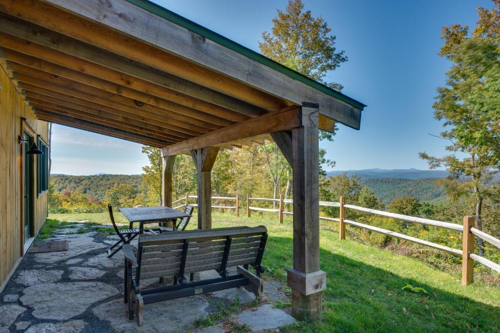 a bench under a pavilion with a picnic table at Unplug, Unwind and Explore Remote Vermont Cabin in Sharon