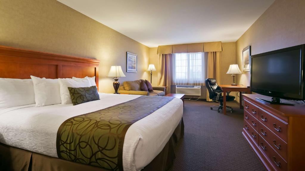 a hotel room with a bed and a flat screen tv at Best Western Plus Kennewick Inn in Kennewick