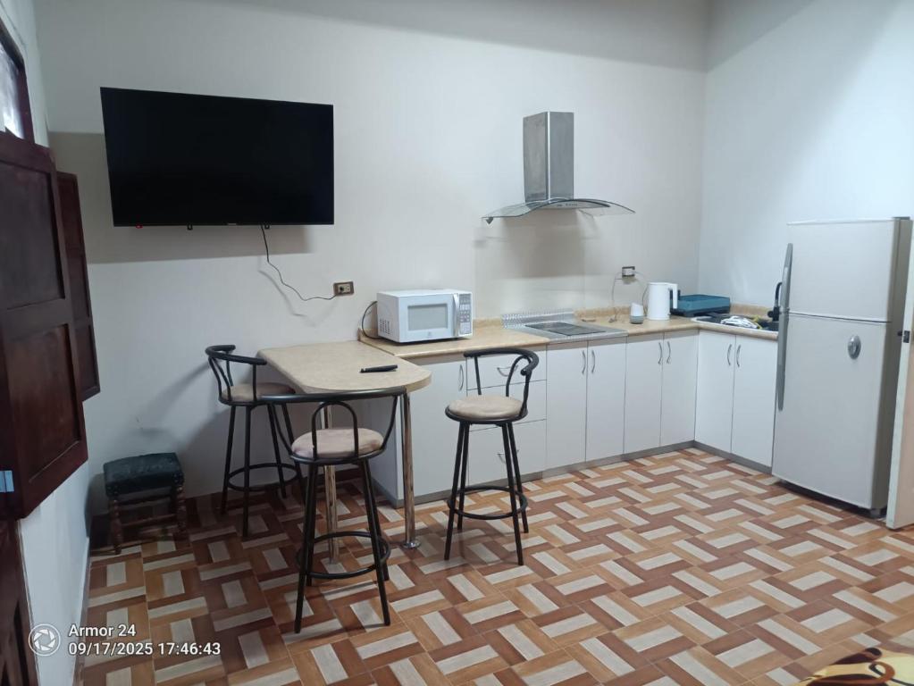 アレキパにあるCasa Puente Bolognesiのキッチン(テーブル、スツール2つ、冷蔵庫付)