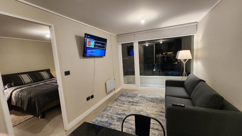 a living room with a couch and a bed and a television at Moderno, nuevo, excelente ubicación, 1D1B, parking in Los Ángeles