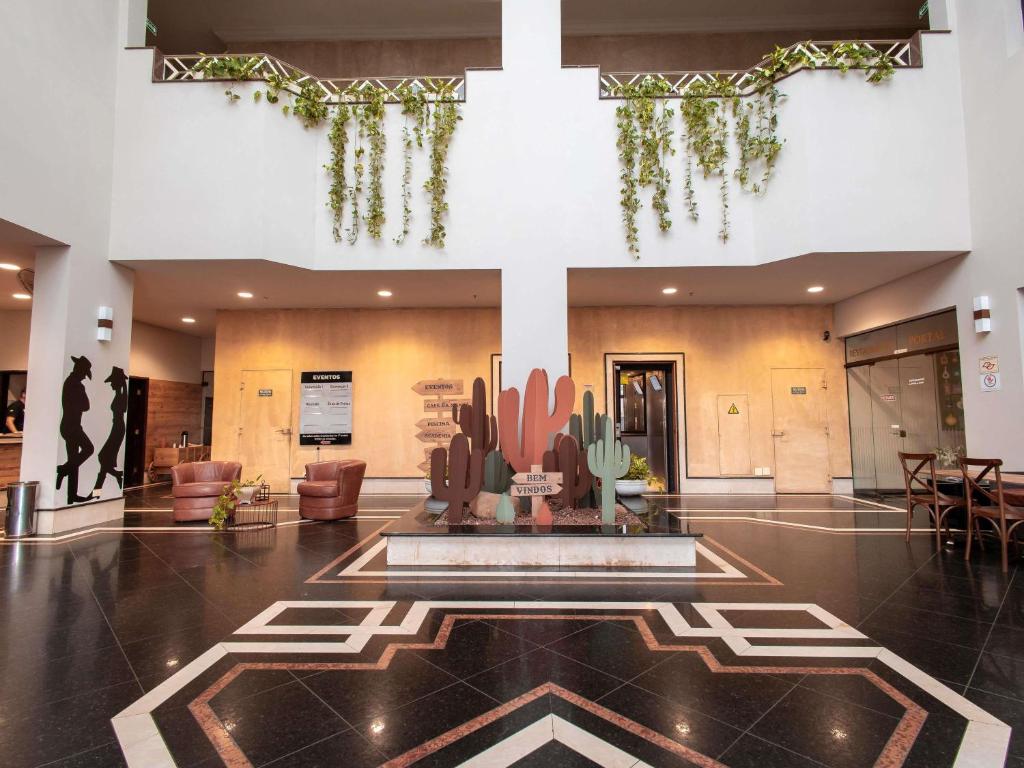 a lobby with a fountain in the middle of a building at ibis Styles Presidente Prudente Portal D'Oeste in Presidente Prudente