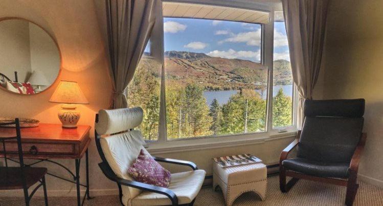 a living room with a large window with a view at Le Belvedère Mont-Tremblant in Mont-Tremblant